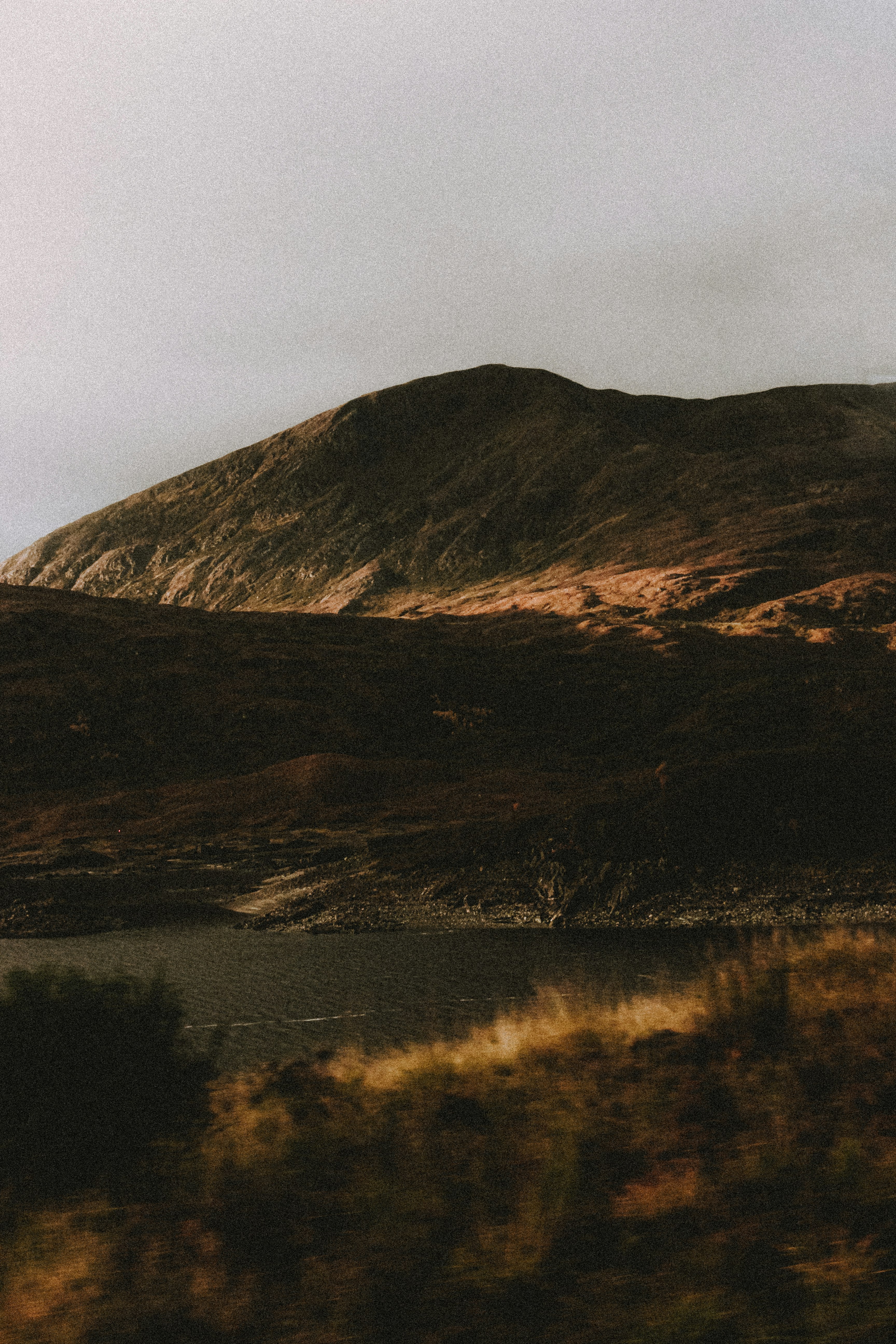 brown mountain under gray sky